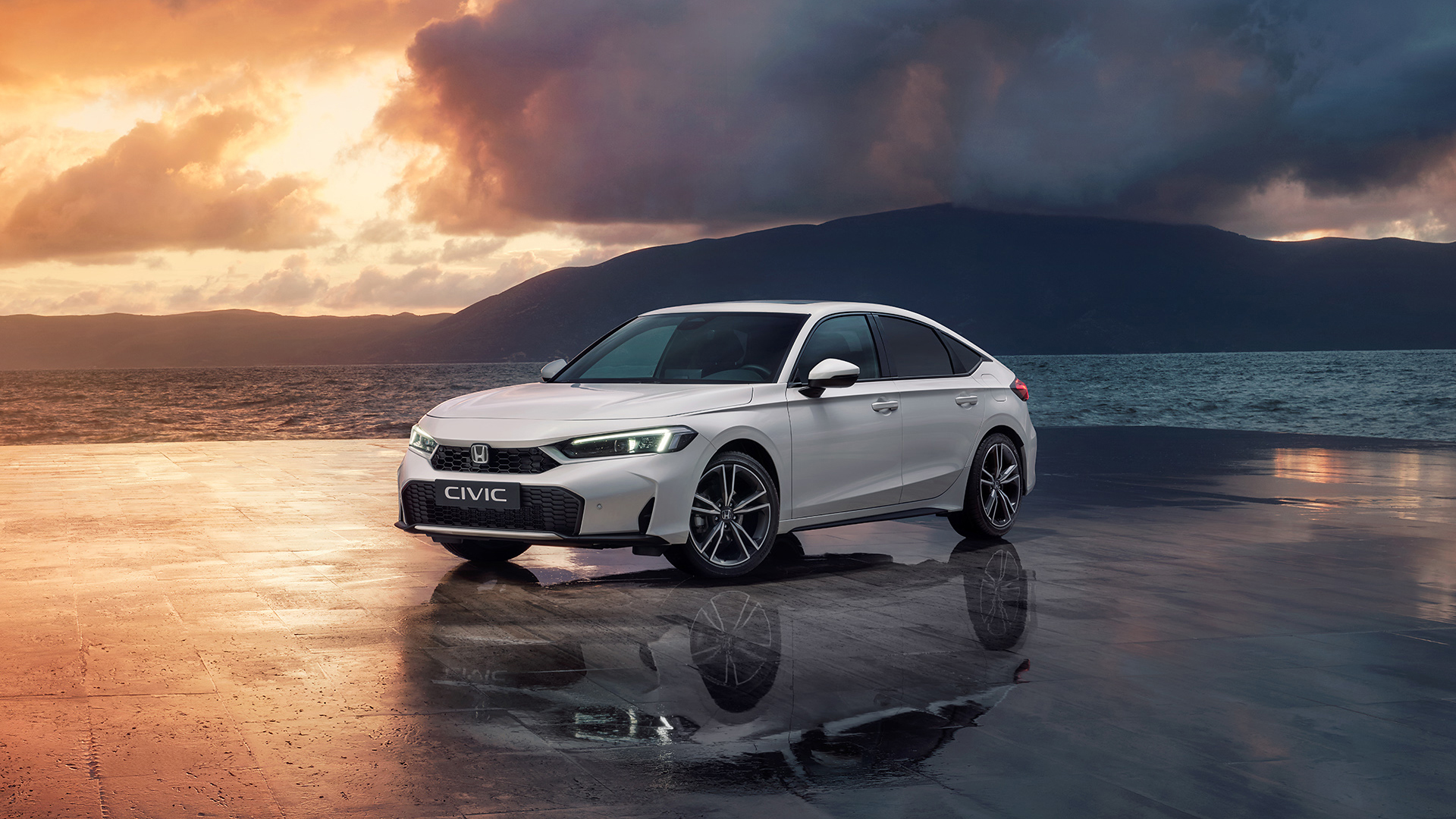 Civic Hybrid parcheggiata vicino all'oceano al tramonto.