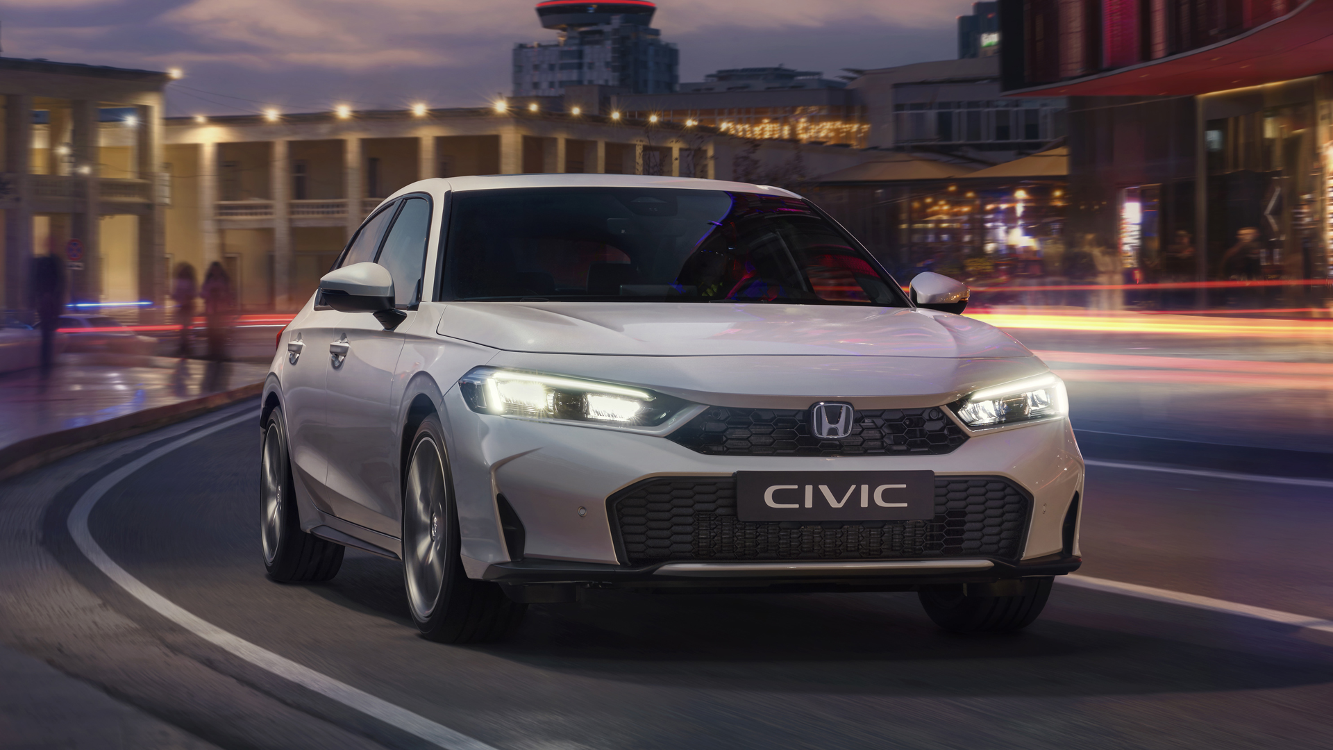 Civic Hybrid in città, su strada, all'alba