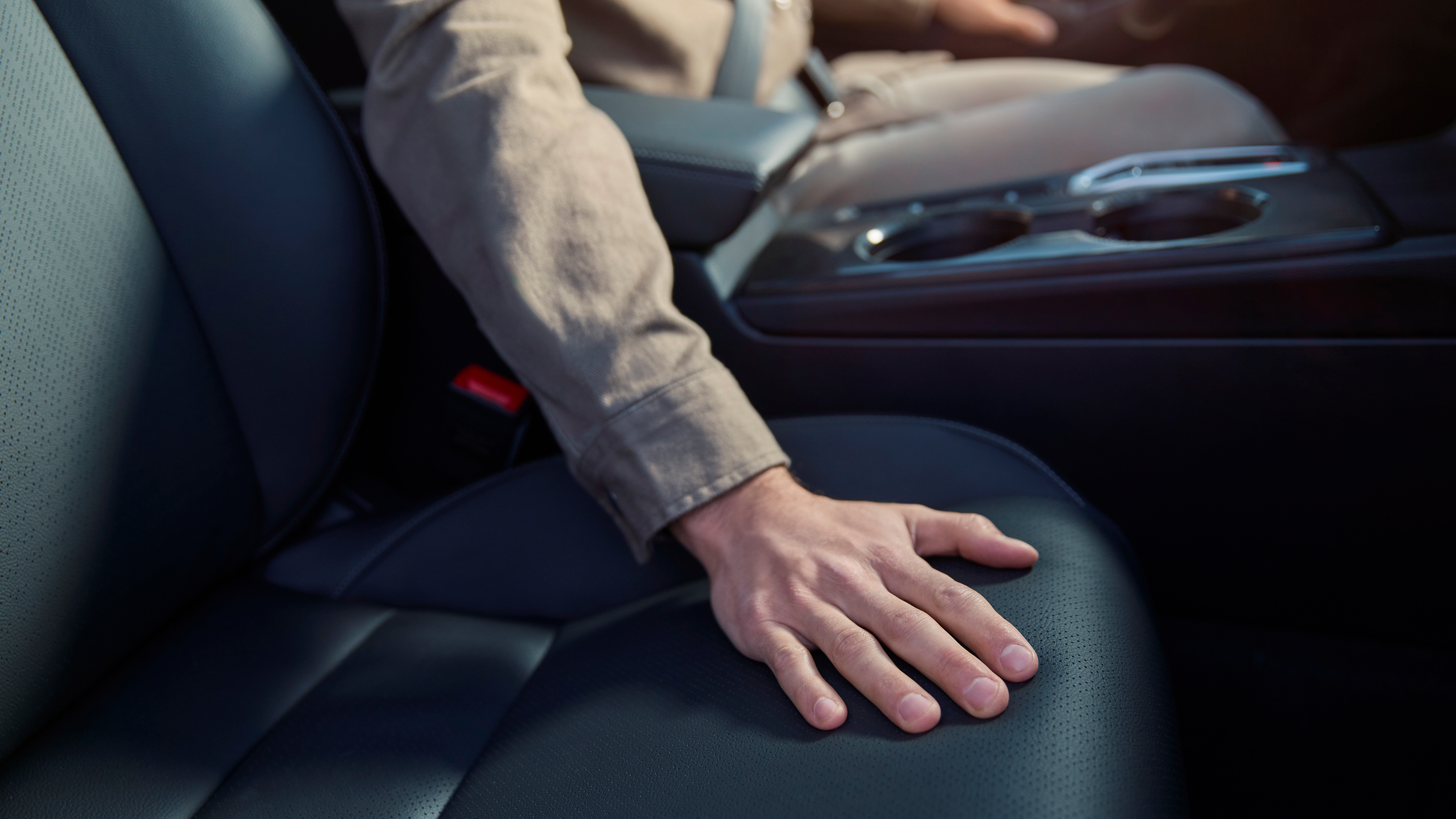 Primo piano di una persona con una mano sul sedile della Honda Civic Hybrid.