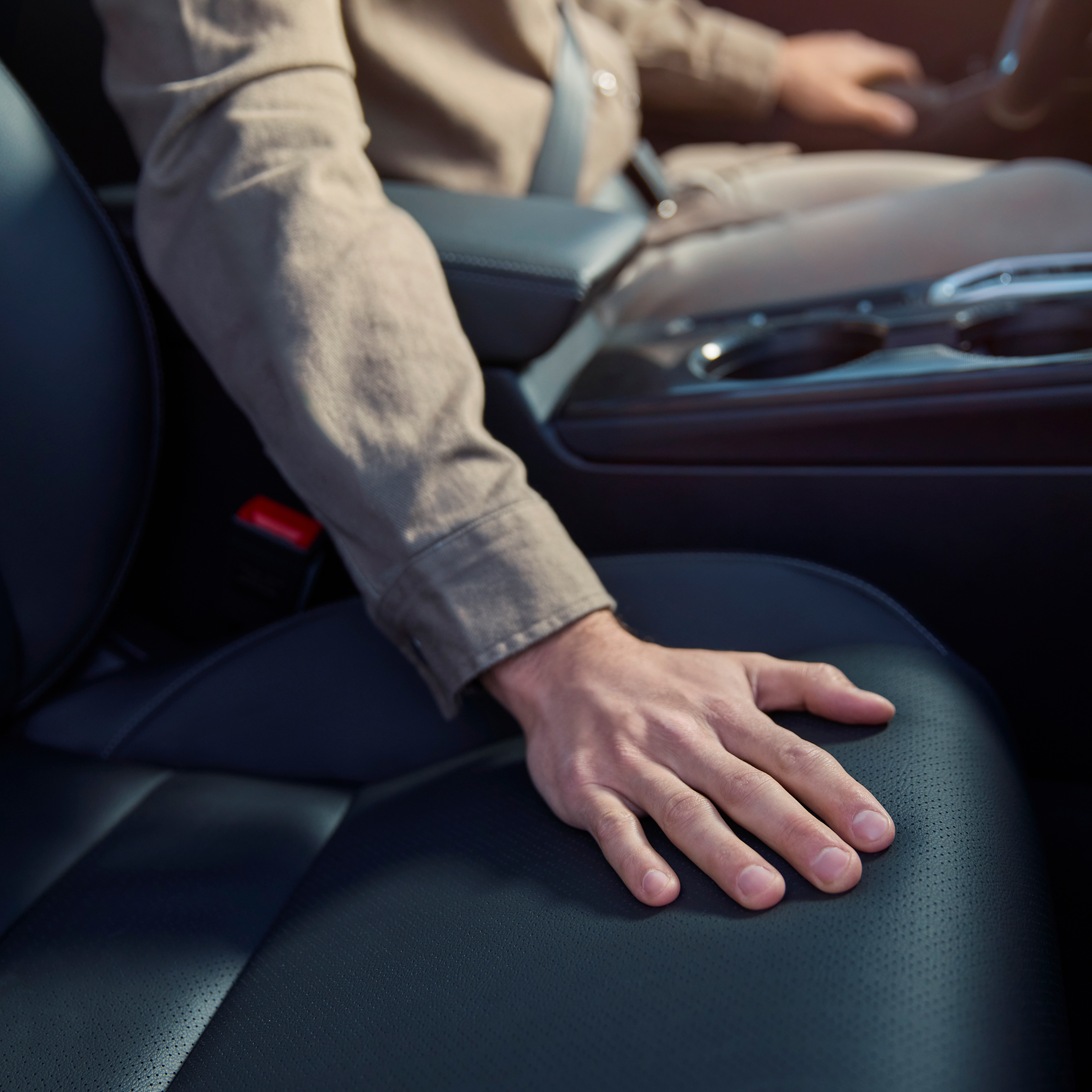 Primo piano di una persona con una mano sul sedile della Honda Civic Hybrid.