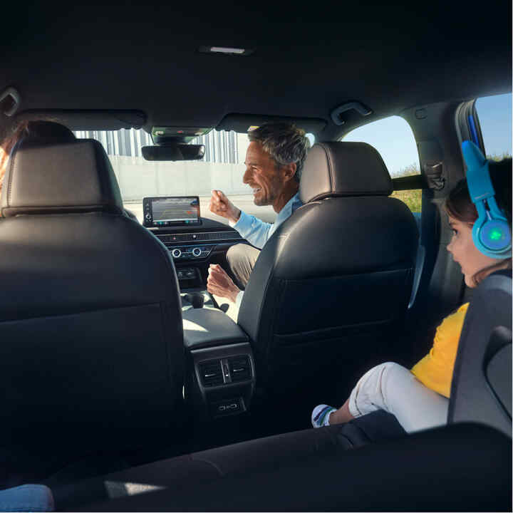 Vista dai sedili posteriori di una famiglia seduta all'interno dell'auto. 