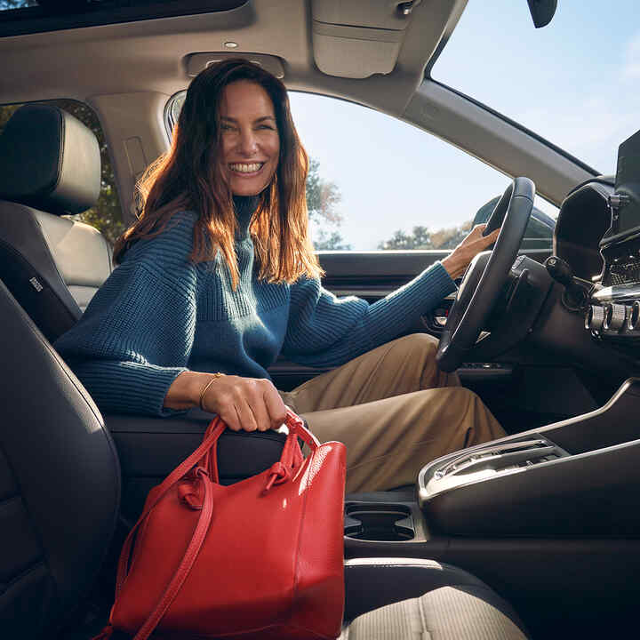 Primo piano degli interni di Honda CR-V Hybrid che mostra il vano portaoggetti nel bracciolo.