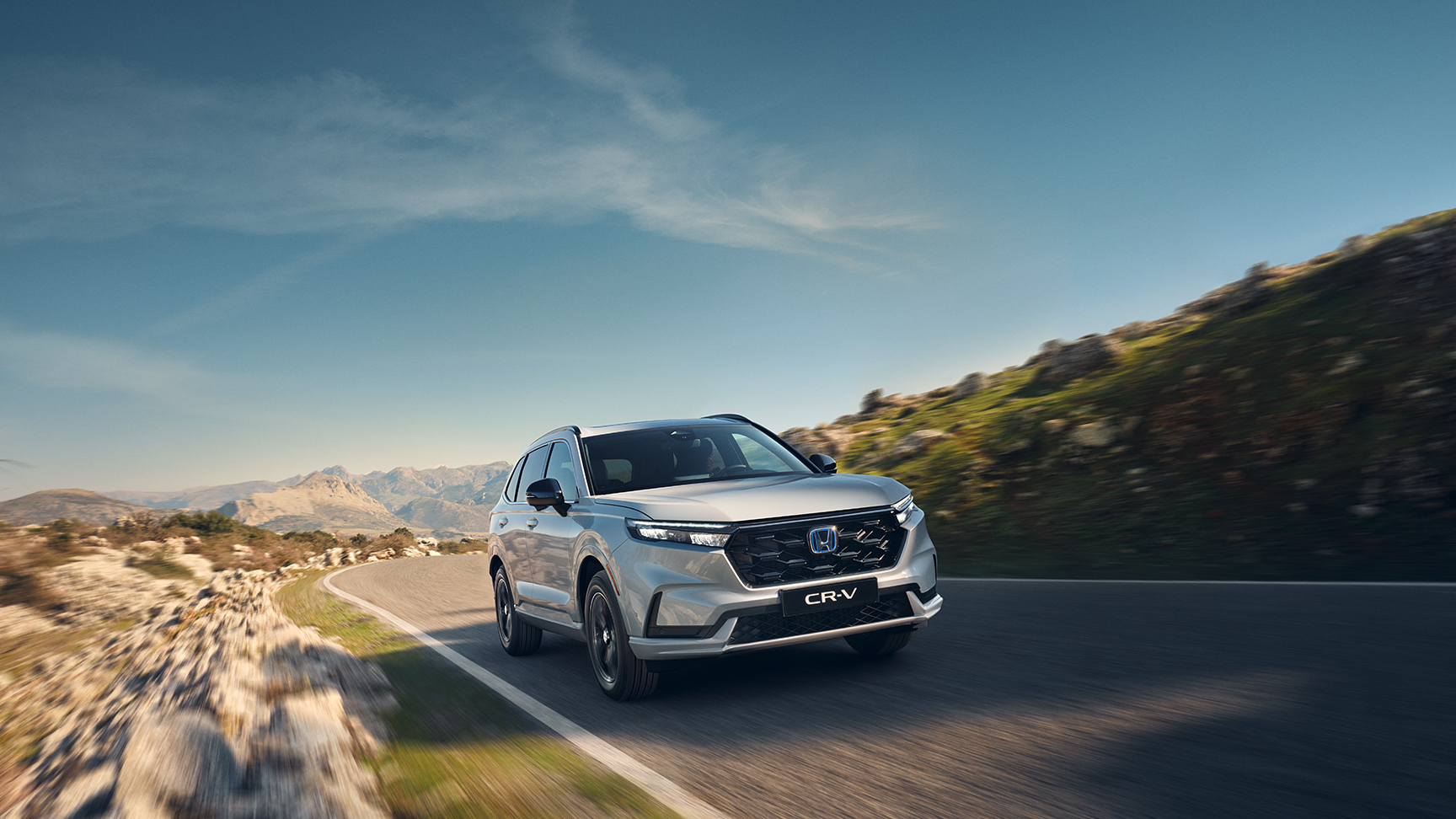 Vista frontale di tre quarti di Honda CR-V Hybrid in un ambiente montano.
