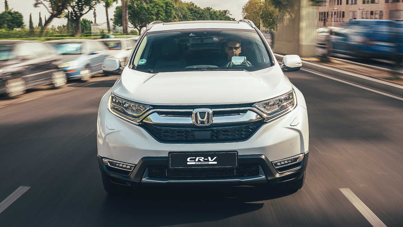 Vista laterale dell'Honda CR-V Hybrid ambientata in una strada.