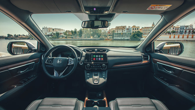 Primo piano del cruscotto interiore dell'Honda CR-V Hybrid ambientato in una strada.