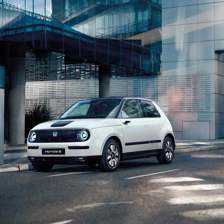 Honda e in strada con edifici sullo sfondo