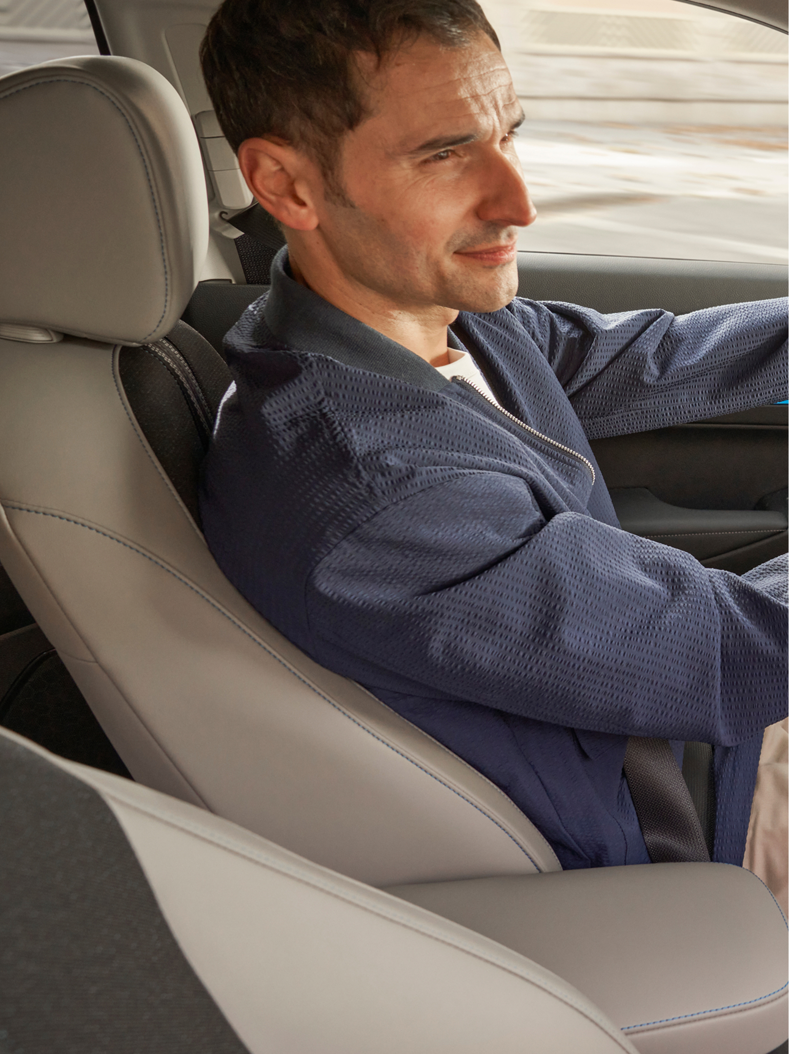 Un conducente siede al volante di una Honda HR-V, visto dal lato del passeggero anteriore, con la plancia interna e una mappa di navigazione visualizzate sullo schermo centrale.