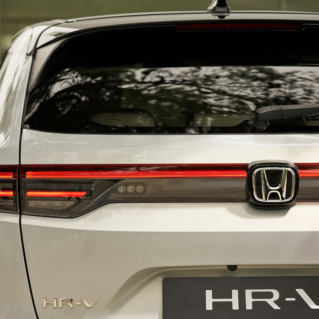 Coppia che cammina accanto all'HR-V parcheggiato fuori dall'edificio.