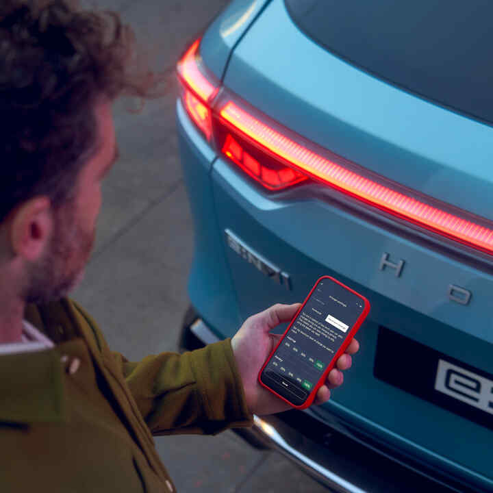 Primo piano dell'app My Honda+ di una persona che utilizza il telefono fuori dall'auto