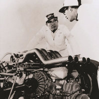 Soichiro Honda al lavoro con un'auto da corsa.