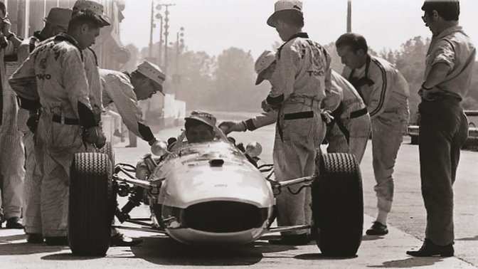 Vista anteriore di un'auto Honda da Formula 1 degli anni '60, con il pilota e gli ingegneri.