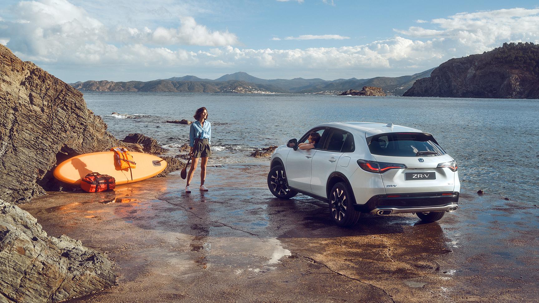 ZR-V bianco sulla costa con donna e canoa