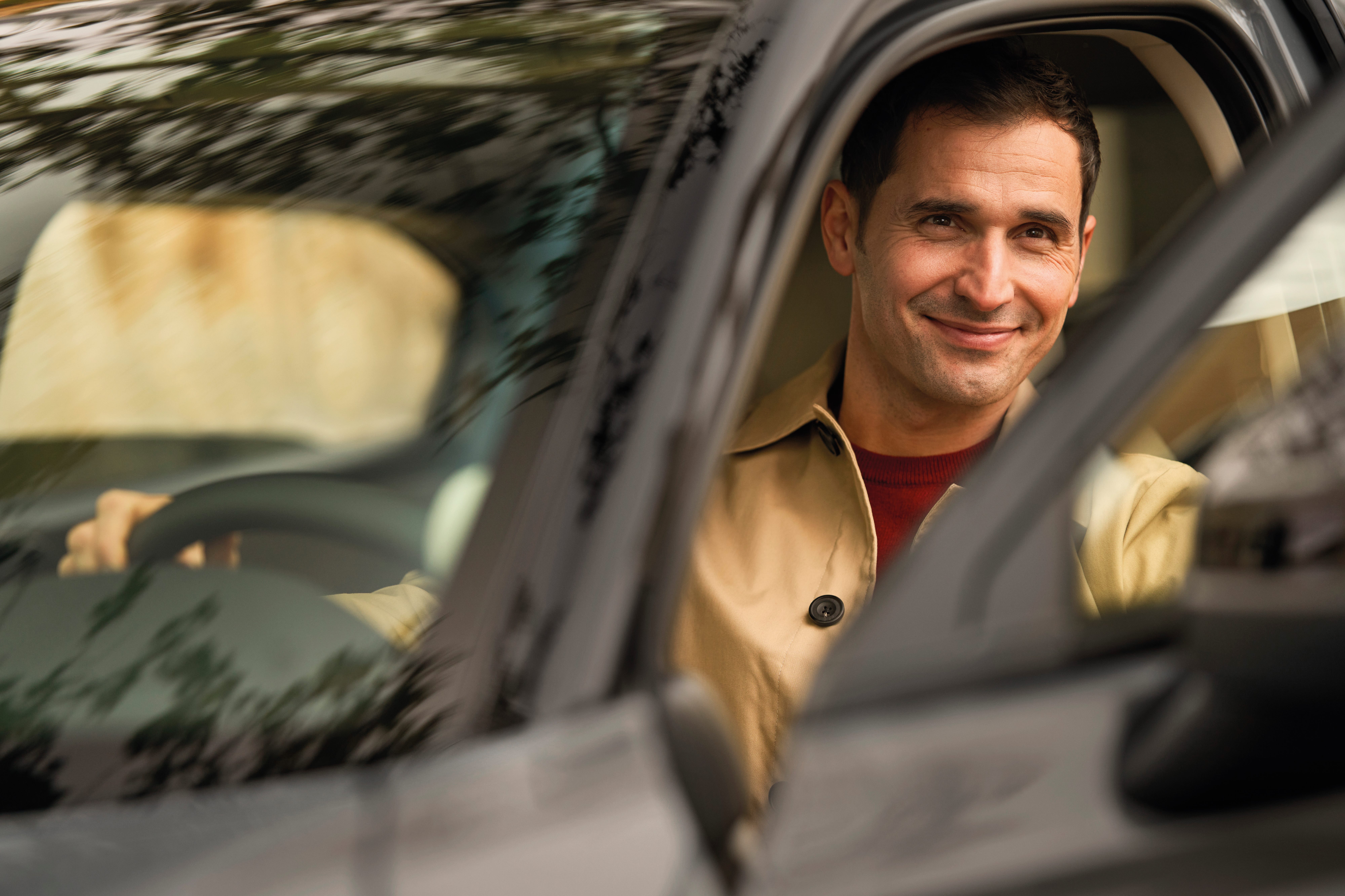Un uomo sorridente al volante di un'auto Honda