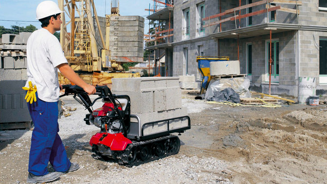 Carrello cingolato utilizzato da un operatore, in cantiere.