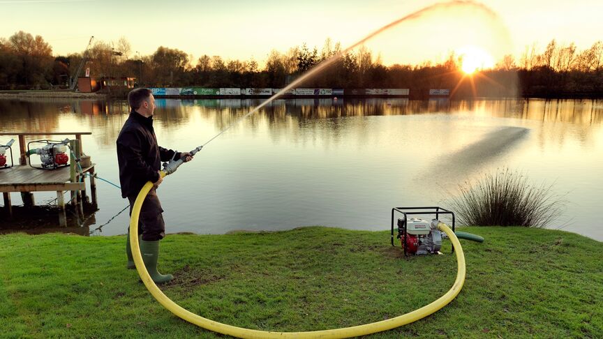 Motopompa ad alta pressione utilizzata da un operatore al lago.