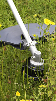 Primo piano della testina del decespugliatore, luogo di utilizzo: giardino.
