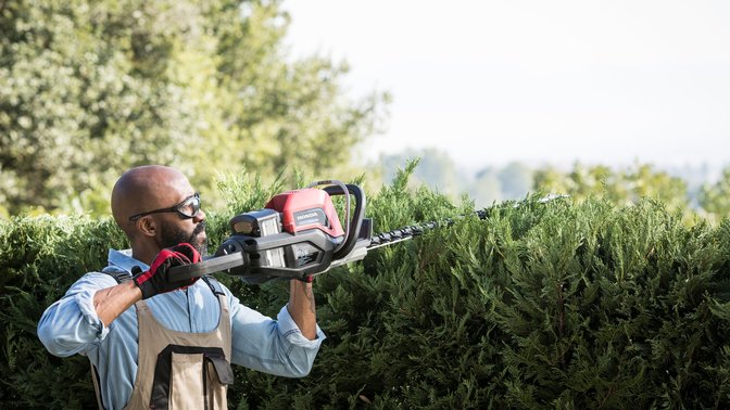 Rear-three quarter view of Honda cordless hedge trimmer with model.