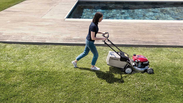 Vista laterale del rasaerba Honda IZY con grande sacco raccoglierba di grande capacità in giardino