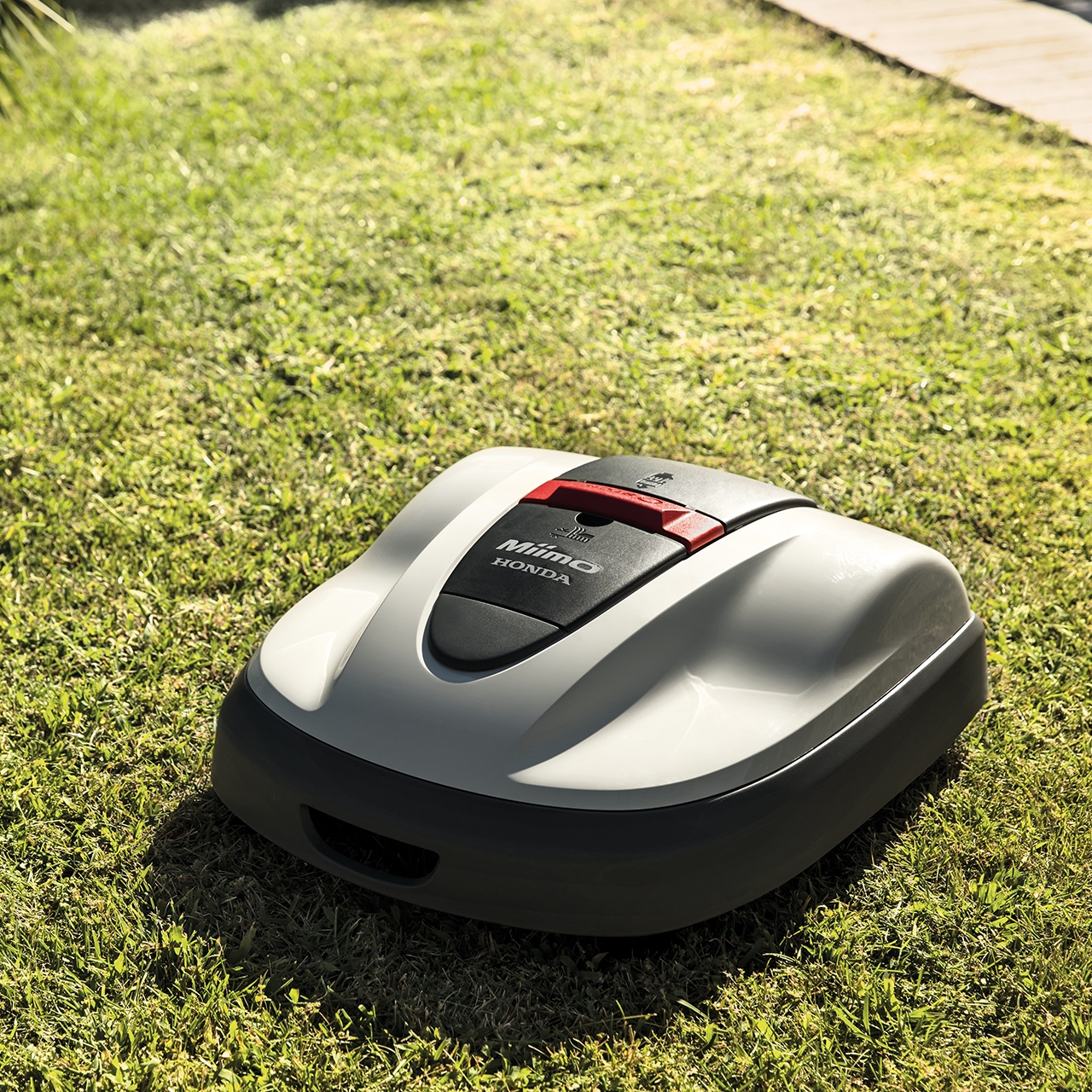 Miimo 3000 al lavoro sul prato di un giardino.