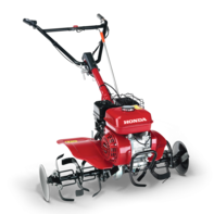 Inquadratura anteriore di tre quarti di una motozappa compatta.