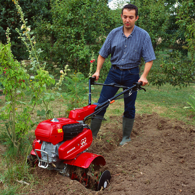 Versatile tiller, being used by model, garden location.