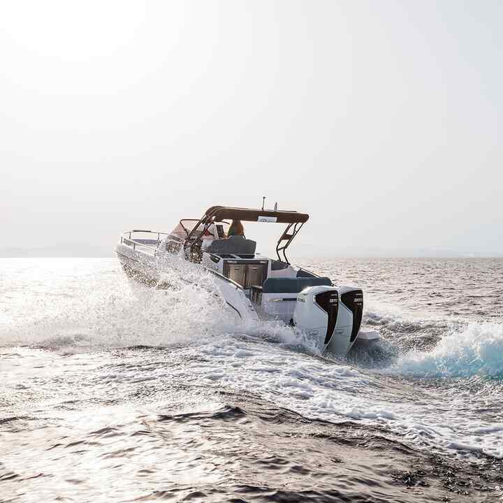 Due modelli alla guida di una barca in mare con motore Honda BF350 v8.