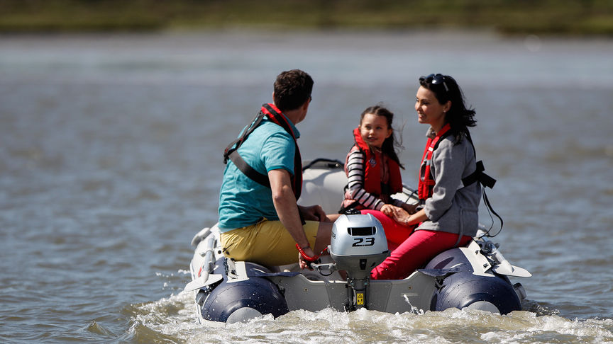 Famiglia sul lago su una barca con Honda BF2.3.