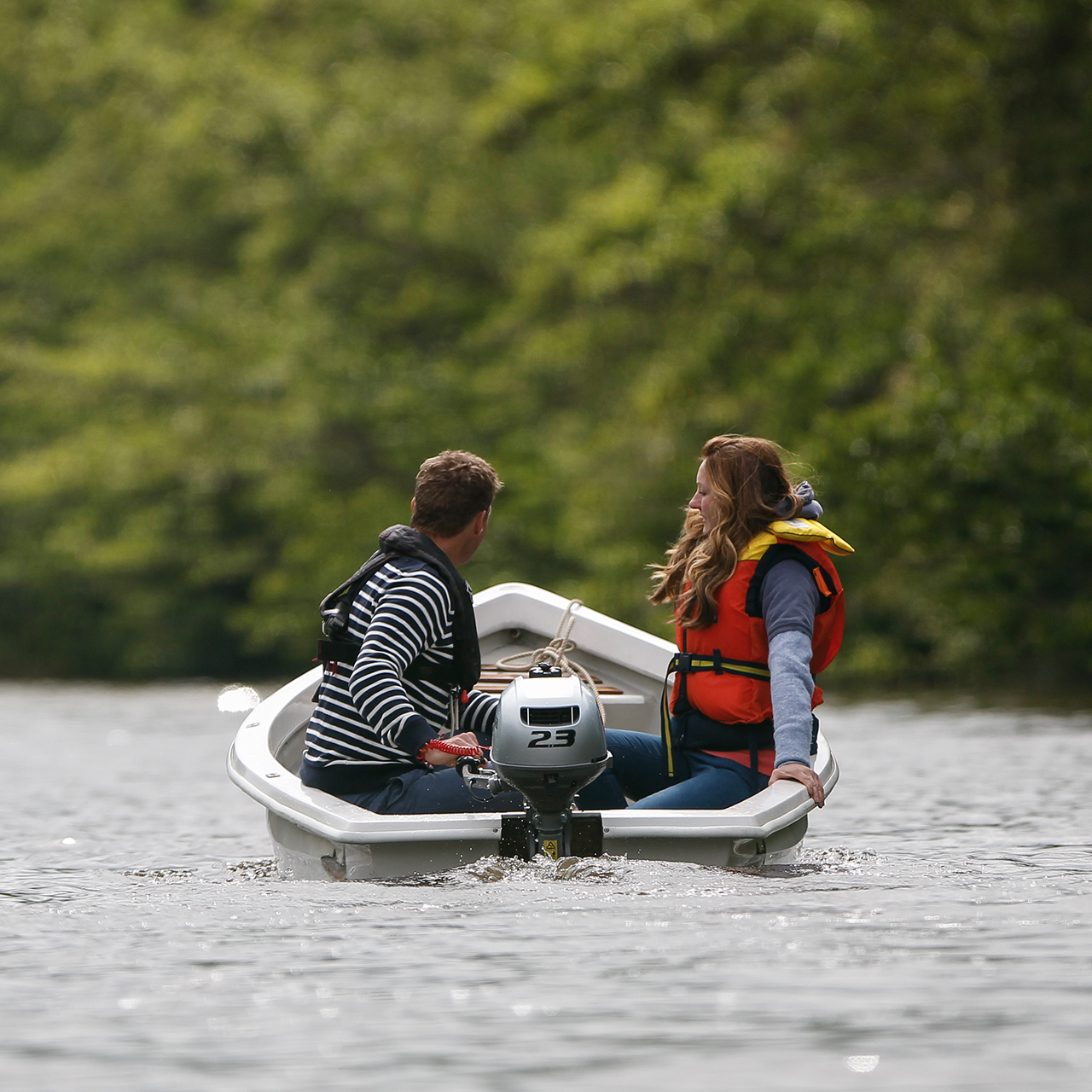 Due persone su una barca in acqua con un motore BF2.3.