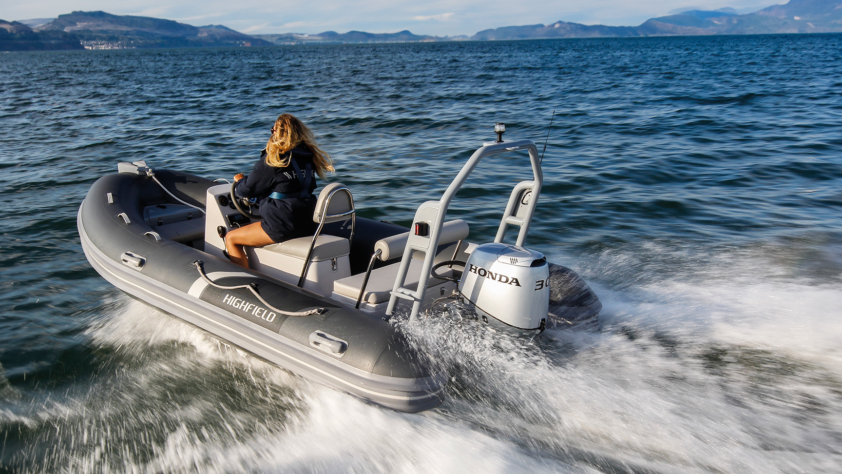 Donna su una barca Highfield con motore Honda BF30 in mare aperto.