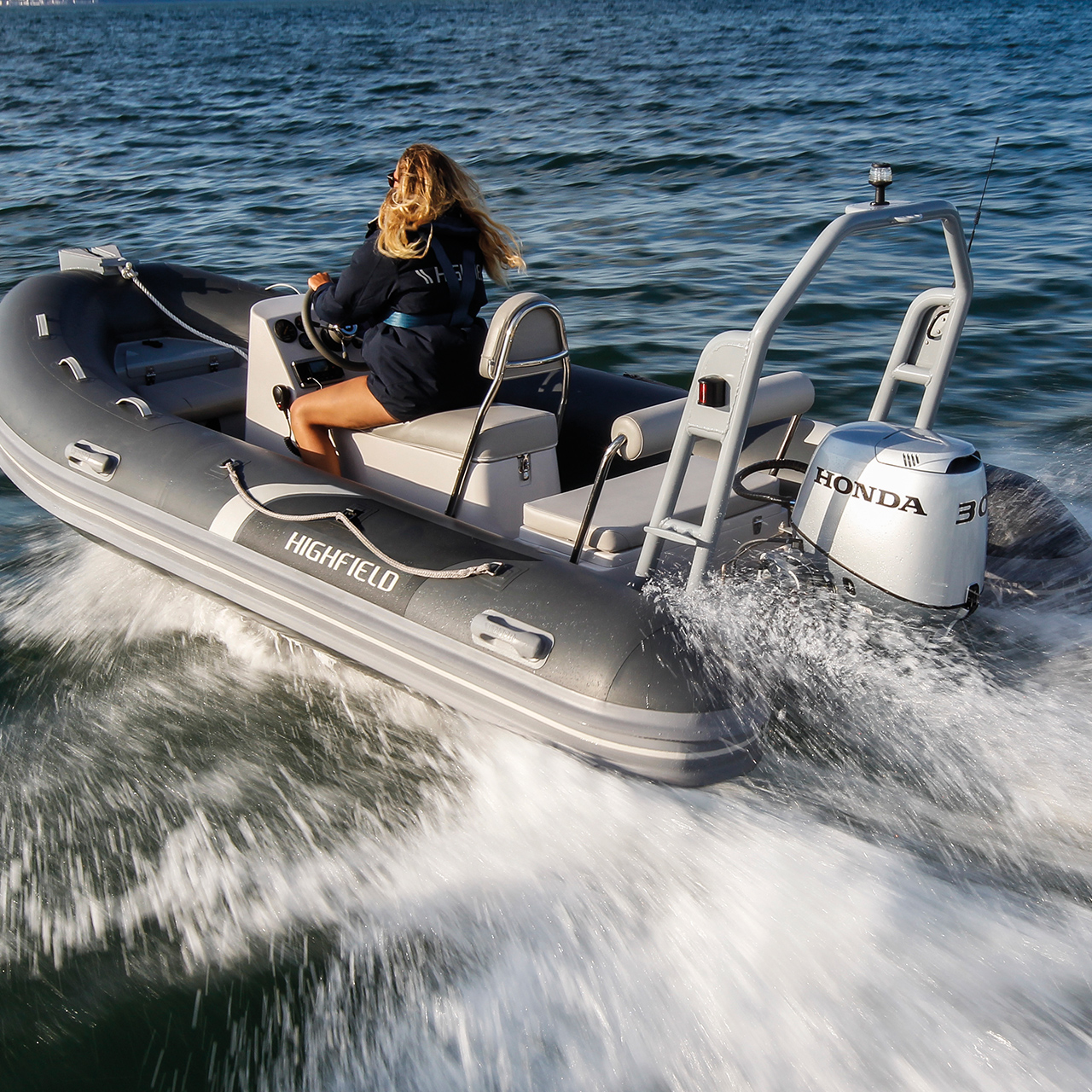 Donna su una barca Highfield con motore Honda BF30 in mare aperto.