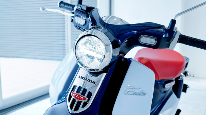 Honda Super Cub, parcheggiato in un luogo moderno.