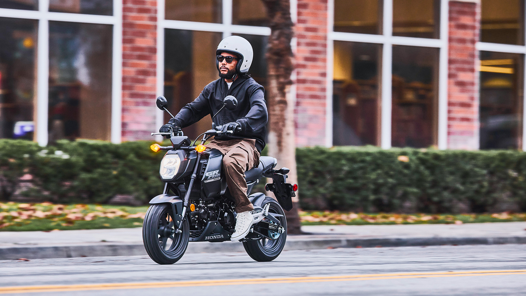 MSX125 Grom nera parcheggiata con i motociclisti che chiacchierano