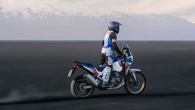 Vista posteriore di tre quarti di Honda Africa Twin guidata tra le dune.