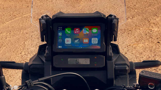 Primo piano del touchscreen di una moto CRF1100L Africa Twin in una località desertica.