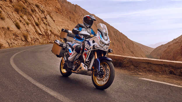 Vista anteriore di motociclista su Honda CRF1100LL Africa Twin Adventure Sports nel deserto.
