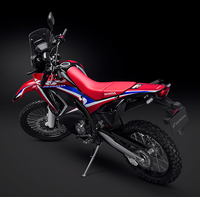 Vista posteriore destra a tre quarti della Honda CRF250 Rally con motociclista.