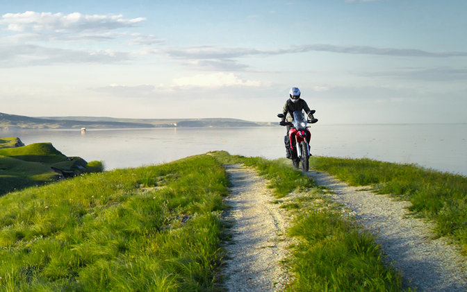 CRF250 Rally lato destro con pilota su una strada sulla costa