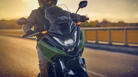 Vista frontale di un modello alla guida della moto NC750X su strada.