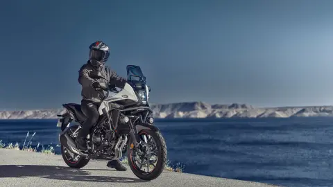 Vista statica di Honda NX500 con pilota vicino alla costa