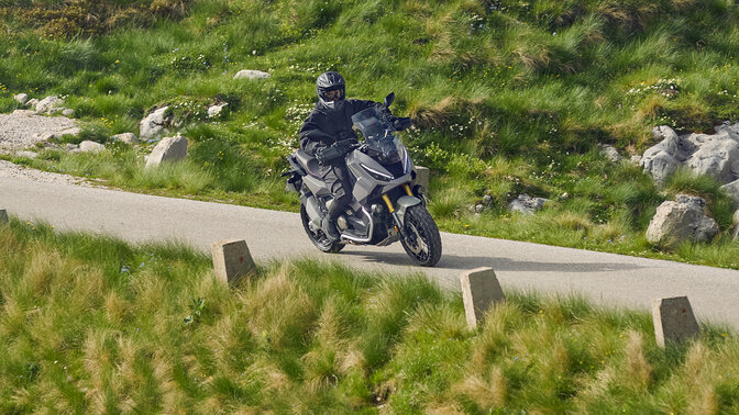 Motociclista su Honda X-ADV in una località di montagna.