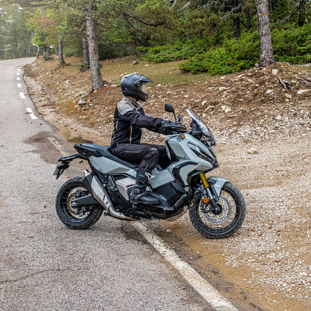 Honda X-ADV, lato destro, con guidatore, moto grigia, sentiero nella foresta