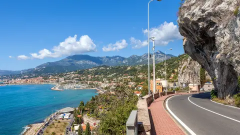 Strada panoramica sotto il cielo blu lungo la costa del Mar Mediterraneo sul confine franco-italiano.