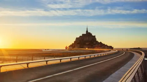 Strada per Mont Saint Michel al tramonto, Normandia. Francia.