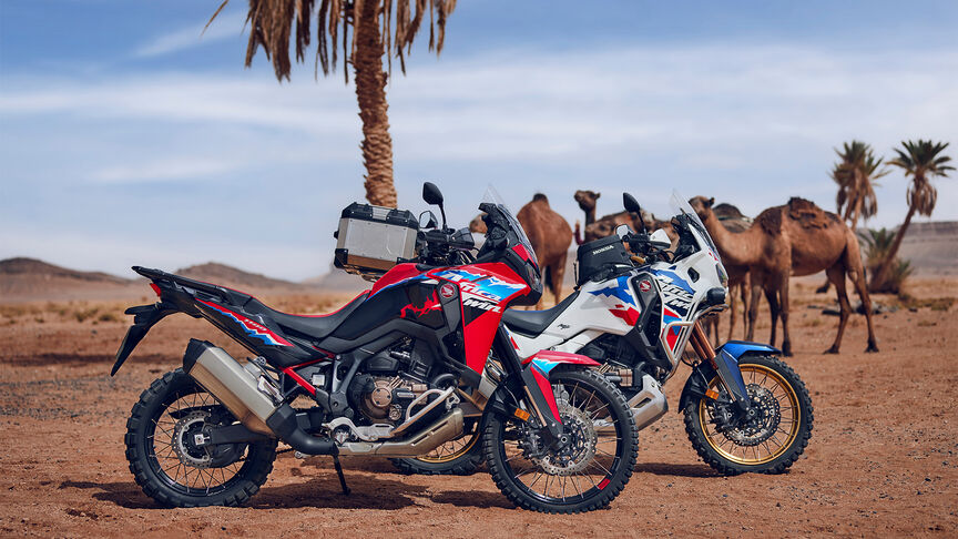 Paesaggio del Marocco con motociclisti Honda Adventure su strada.