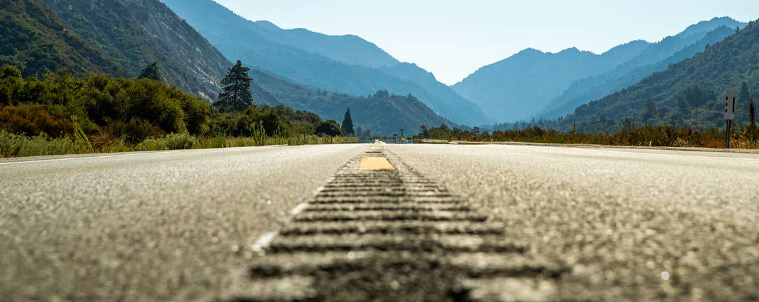 Strada asfaltata aperta che porta verso le montagne
