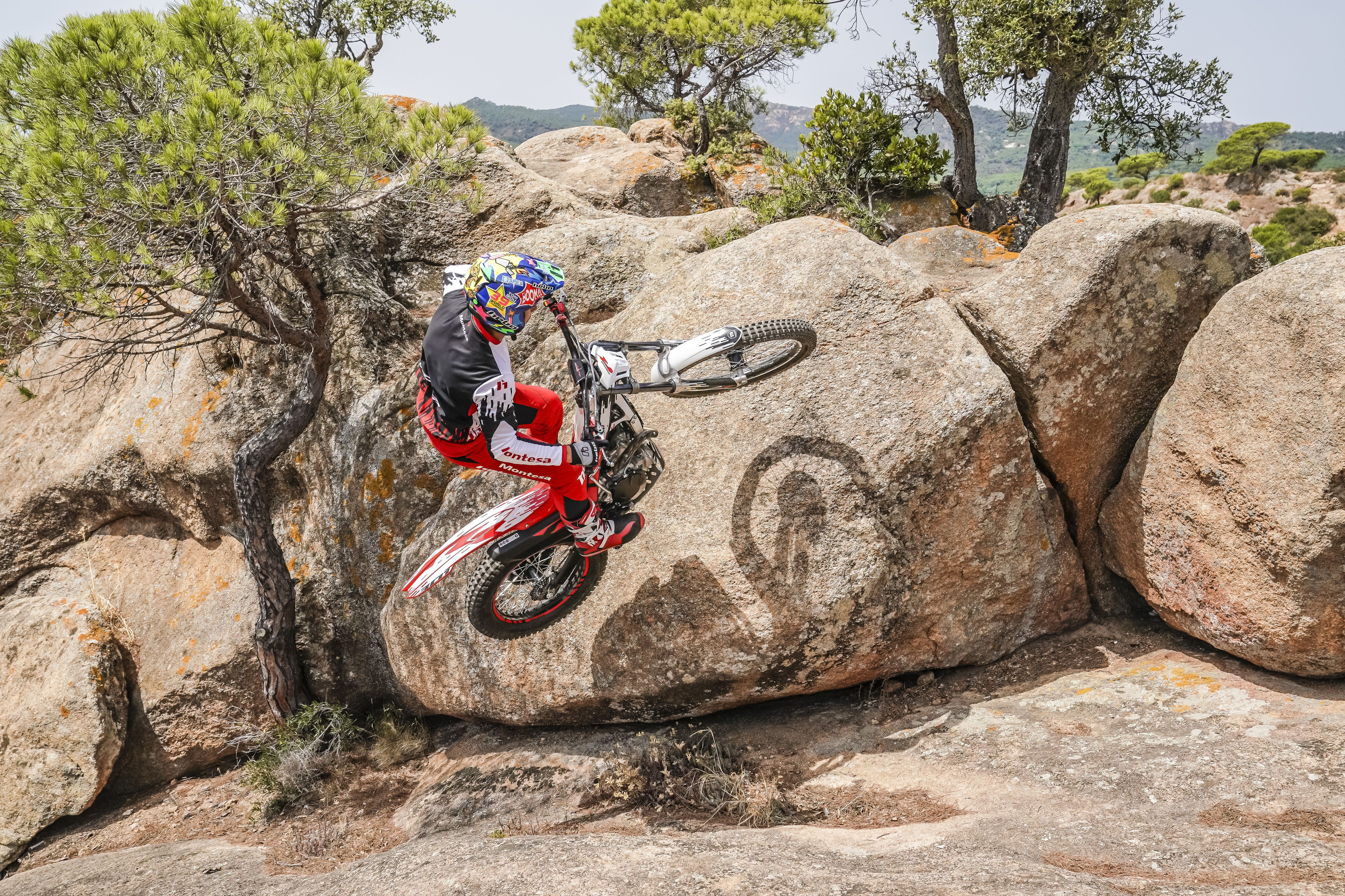 Pilota in impennata su una Montesa Cota 301RR su una formazione rocciosa.