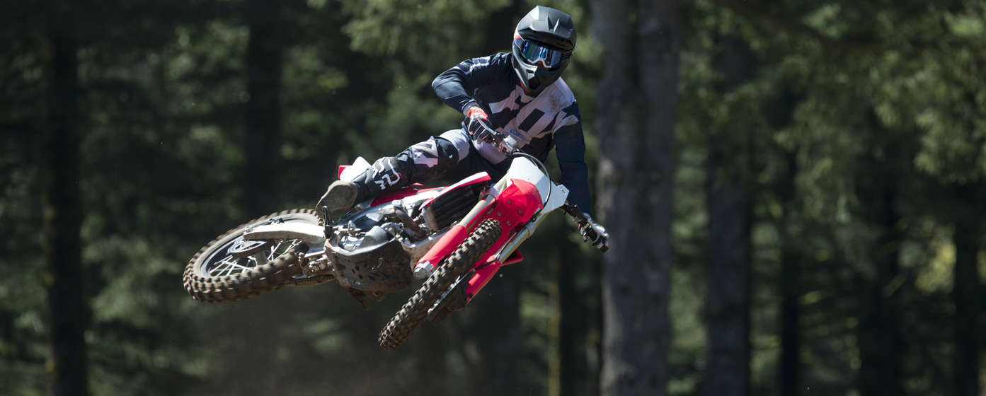 Vista frontale della CRF450R durante un salto, con il pilota in sella.
