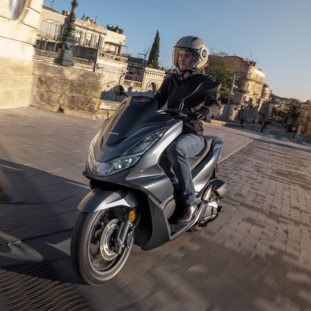 Honda PCX125 con paesaggio urbano alle spalle