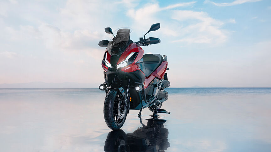 Vista frontale di tre quarti di Honda ADV350 in una località costiera.