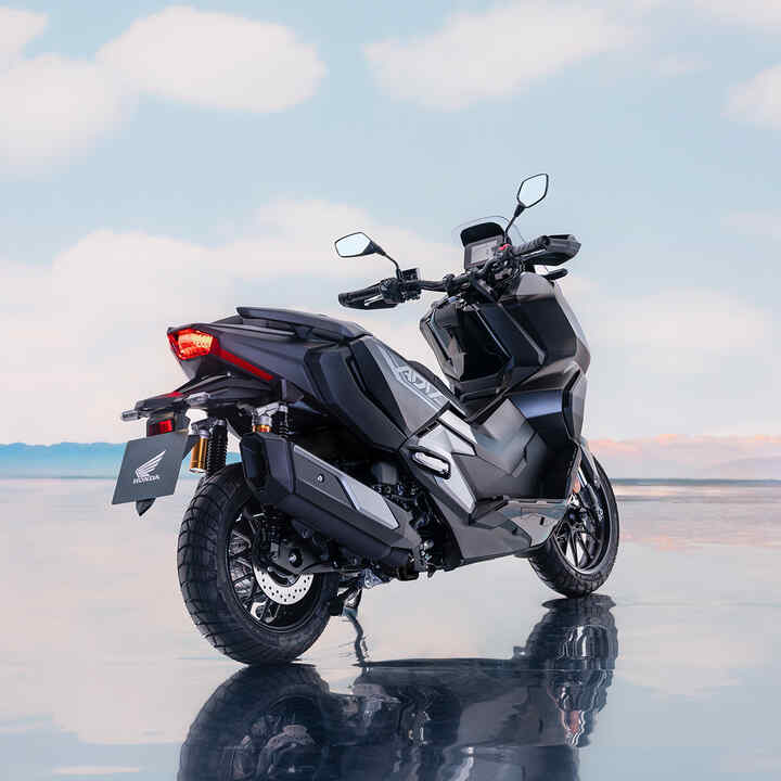 Vista posteriore di tre quarti di Honda ADV350 in una località costiera. 
